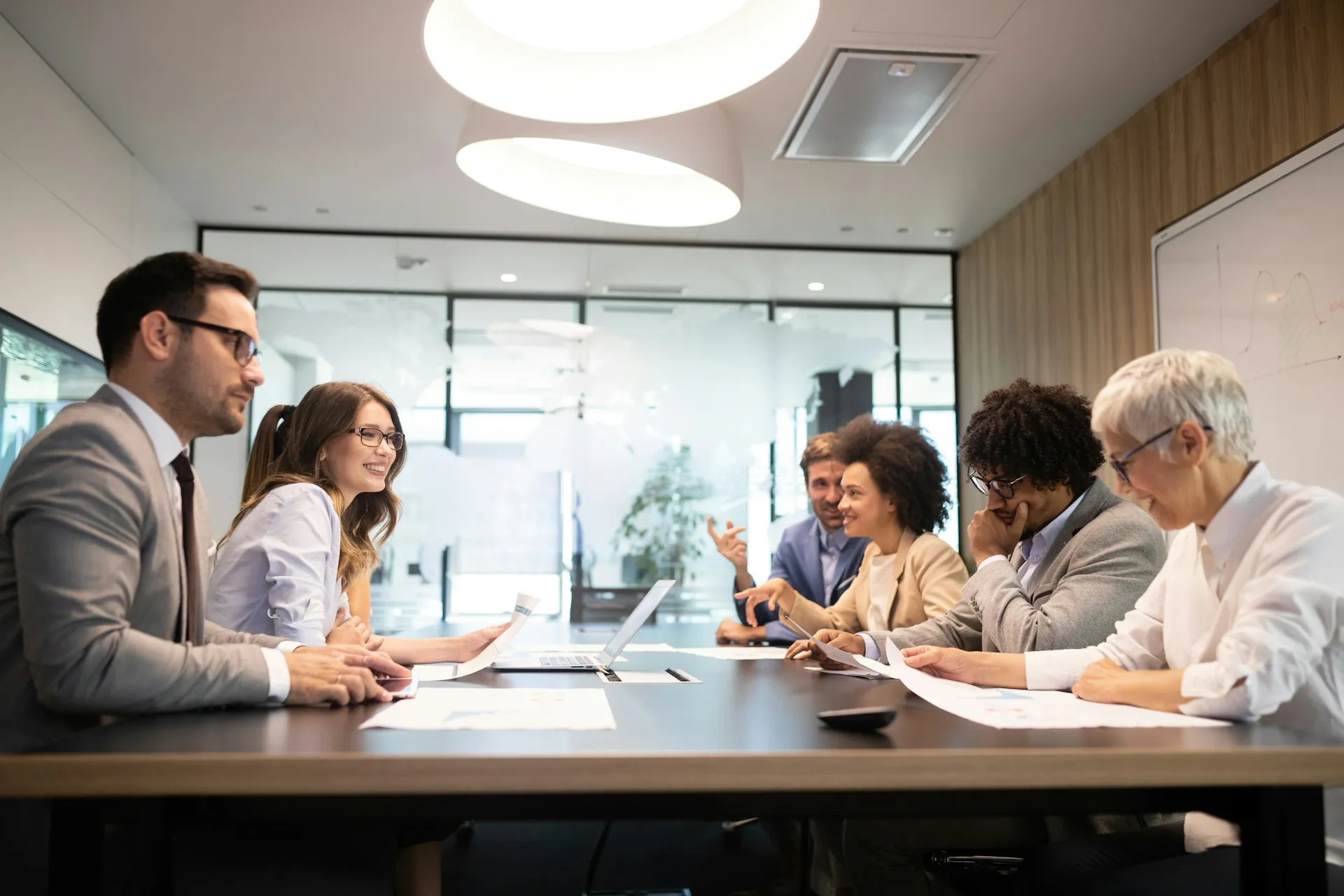 Group of professionals engaged in a meeting around a conference table.