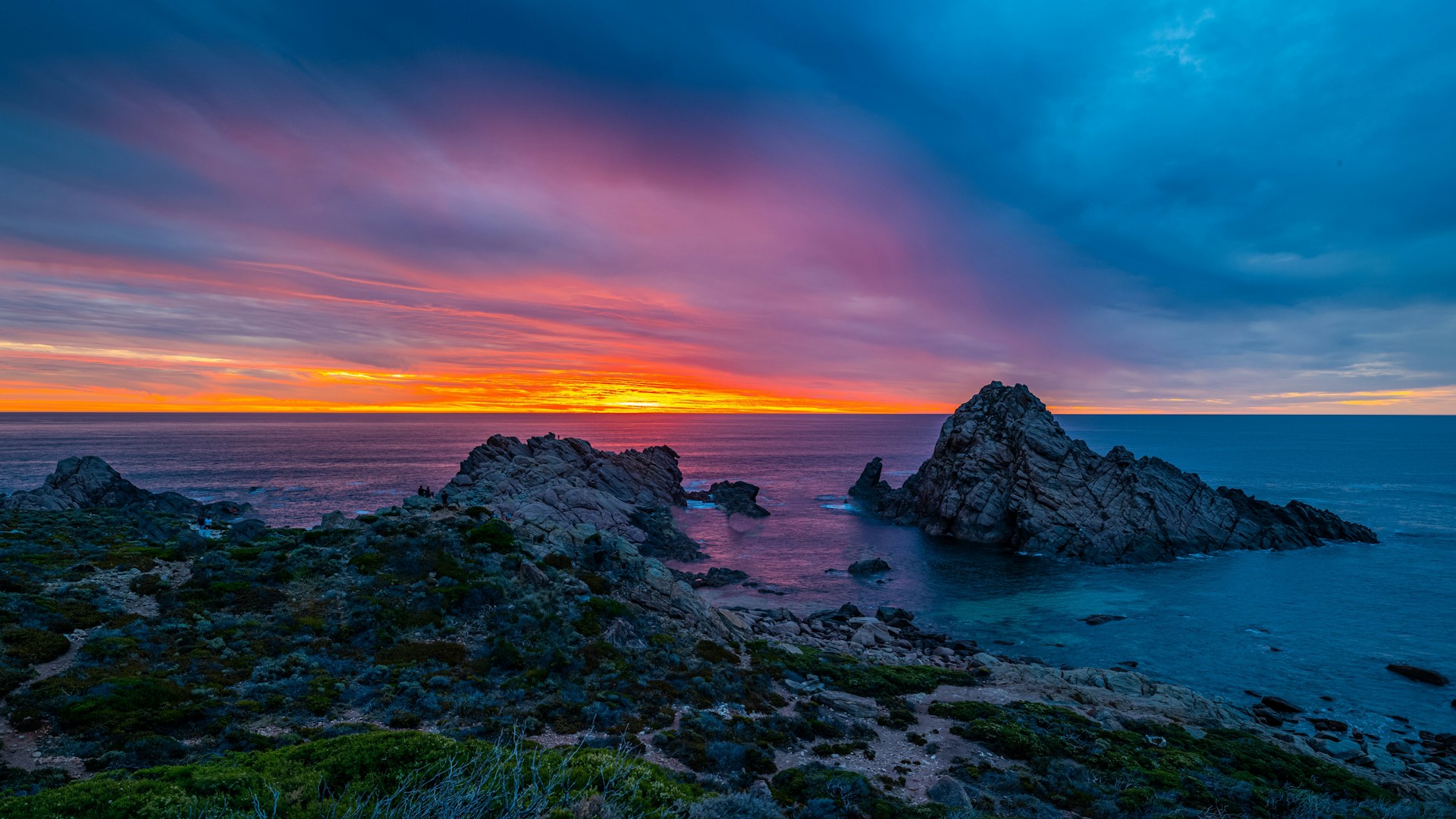 Sunset at Sugarloaf Rock in Margaret River, Western Australia, with vibrant orange and pink skies over the ocean.