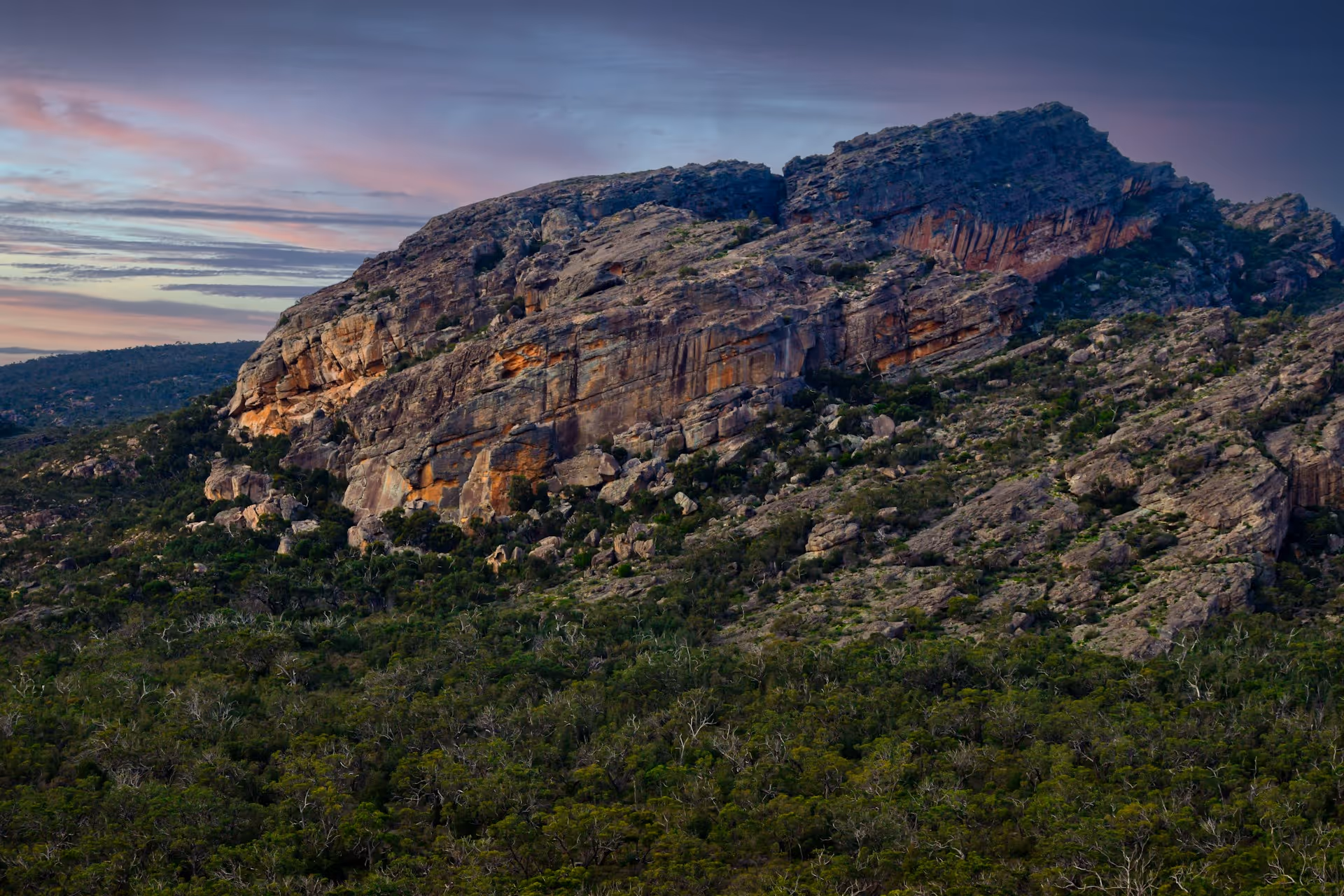 Rocky cliffs of Mount Zero Road surrounded by dense bushland in Halls Gap, Victoria.