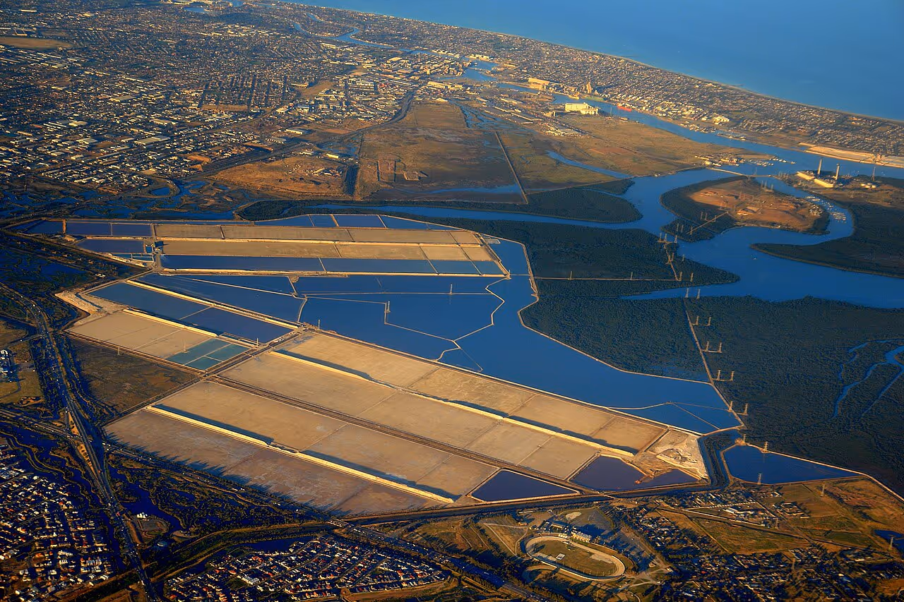 Aerial view of Adelaide’s Port River region showing Globe Derby Park, parts of Mawson Lakes, Dry Creek salt pans, Garden Island, Torrens Island, Gillman, Lefevre Peninsula, Port Adelaide, and surrounding mangroves. Photo by Gary Sauer-Thompson, Wikimedia Commons: https://commons.wikimedia.org/wiki/File:Port_Adelaide_aerial_view.jpg, CC BY-SA 2.0.