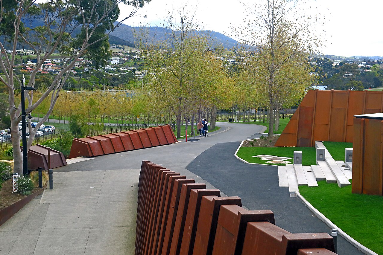View of the landscaped pathway and modern architectural features leading from the Museum of Old and New Art (MONA) towards Moorilla in Tasmania. Credit: Tim J Keegan, Wikimedia Commons: https://commons.wikimedia.org/wiki/File:View_to_north_Moorilla_from_MONA_2019.jpg