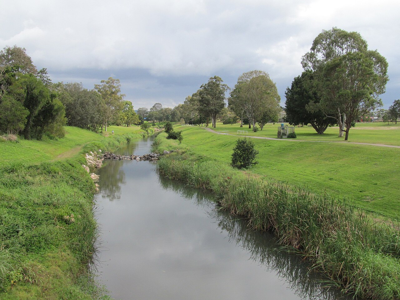 Kedron Brook looking west from the Shaw Road bridge, Kalinga, Queensland. Credit: Orderinchaos, Wikimedia Commons: https://commons.wikimedia.org/wiki/File:Kedron_Brook_W_from_Shaw_Rd_Kalinga.jpg