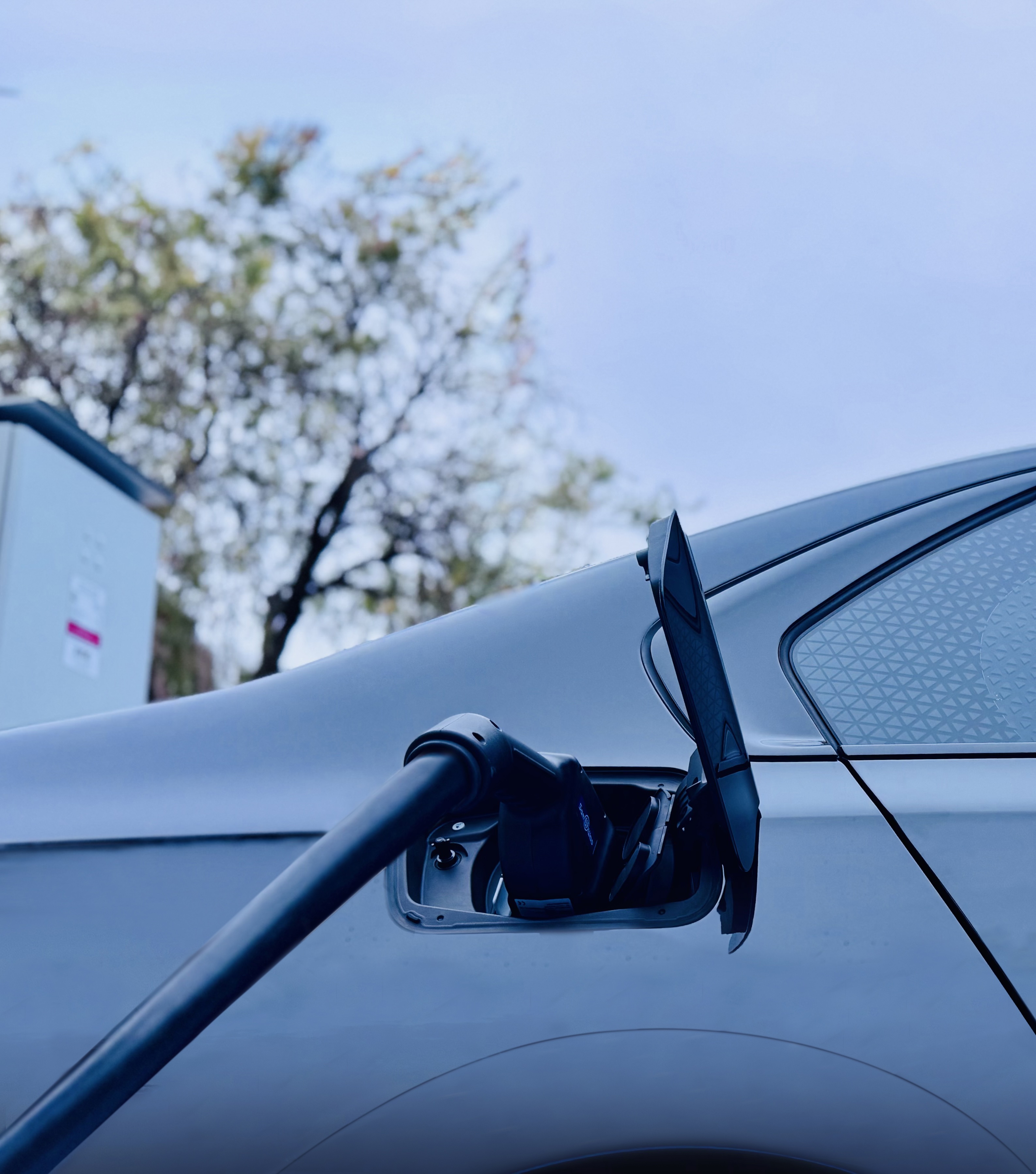 Evoke BMW i7 chauffeur vehicle charging at an EV charging station in Sydney.