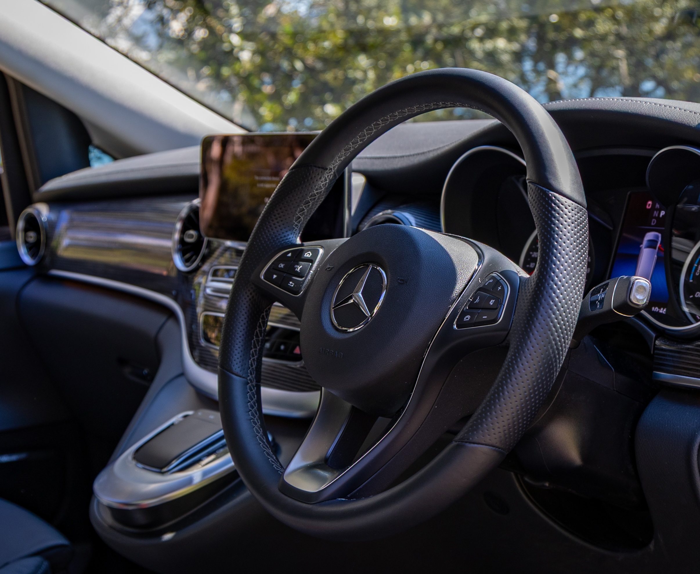 Mercedes EQV interior featuring the steering wheel, dashboard display and premium cabin finishes ready for chauffeur-driven travel.
