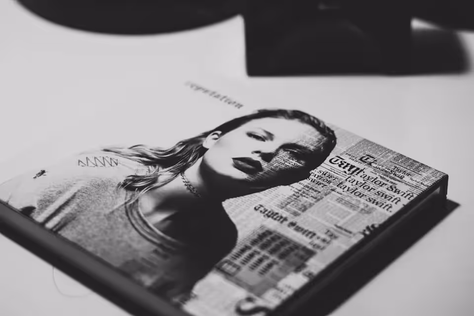 A black and white close-up of Taylor Swift's "Reputation" album cover, featuring a portrait of the singer overlaid with newspaper-style text.
