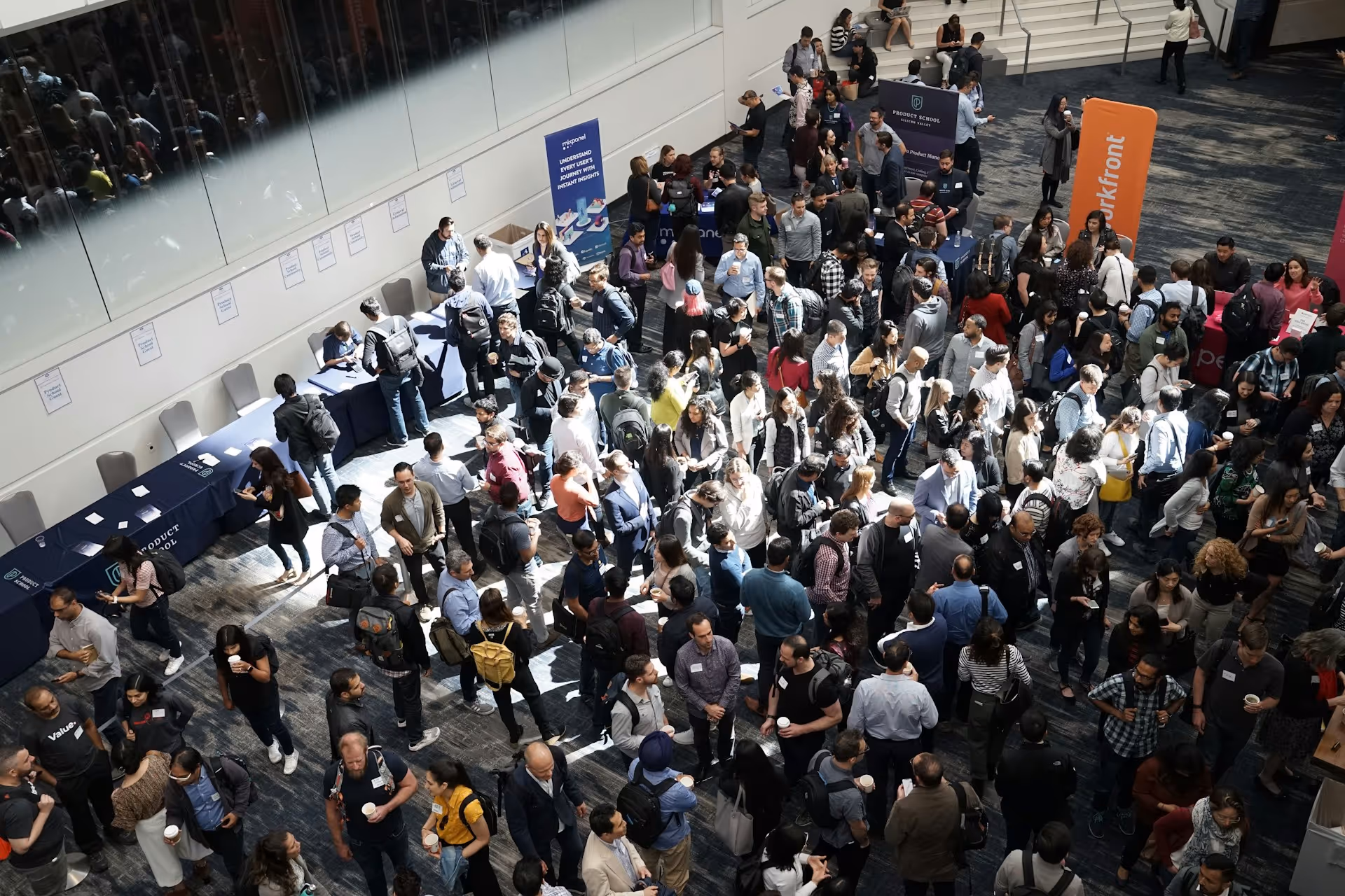 A large crowd of people mingling and networking in a conference hall. 