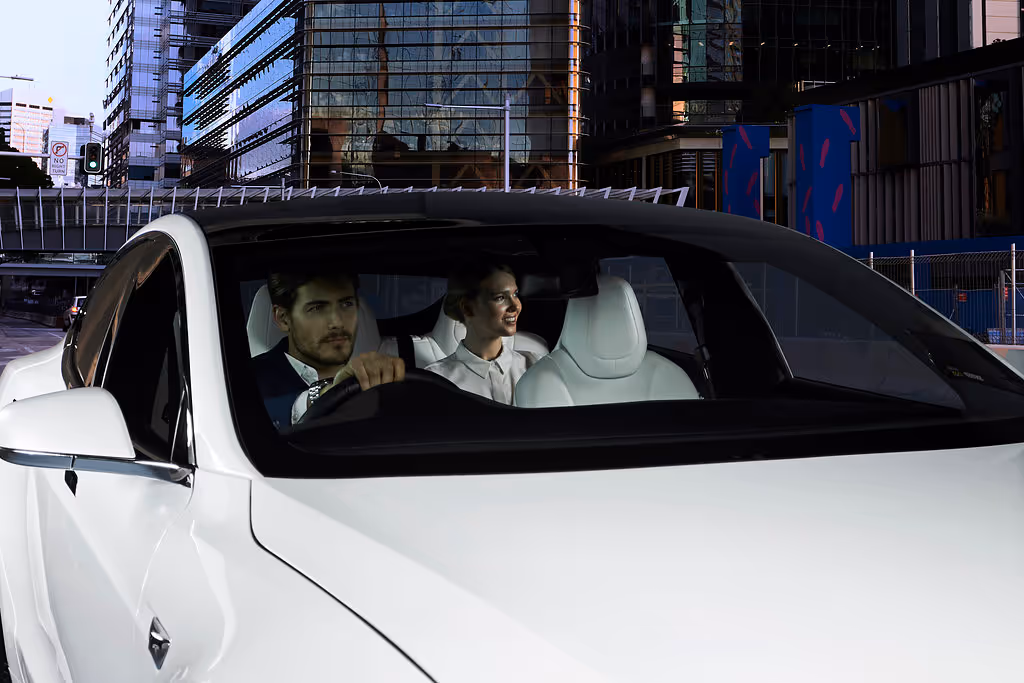 A professional chauffeur with a female passenger seated at the rear.