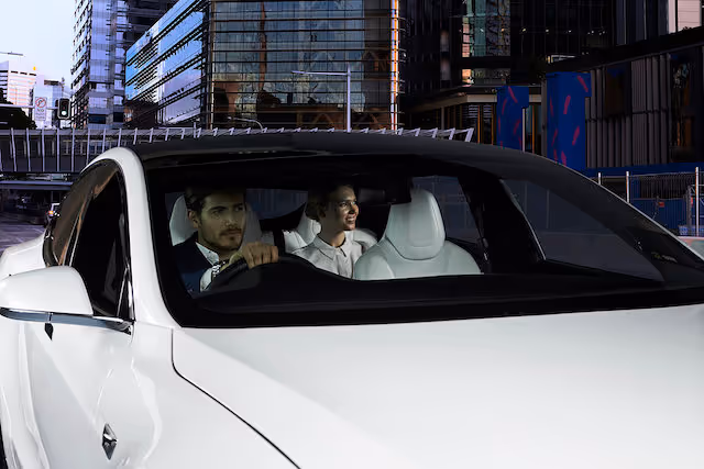 A professional chauffeur with a female passenger seated at the rear.