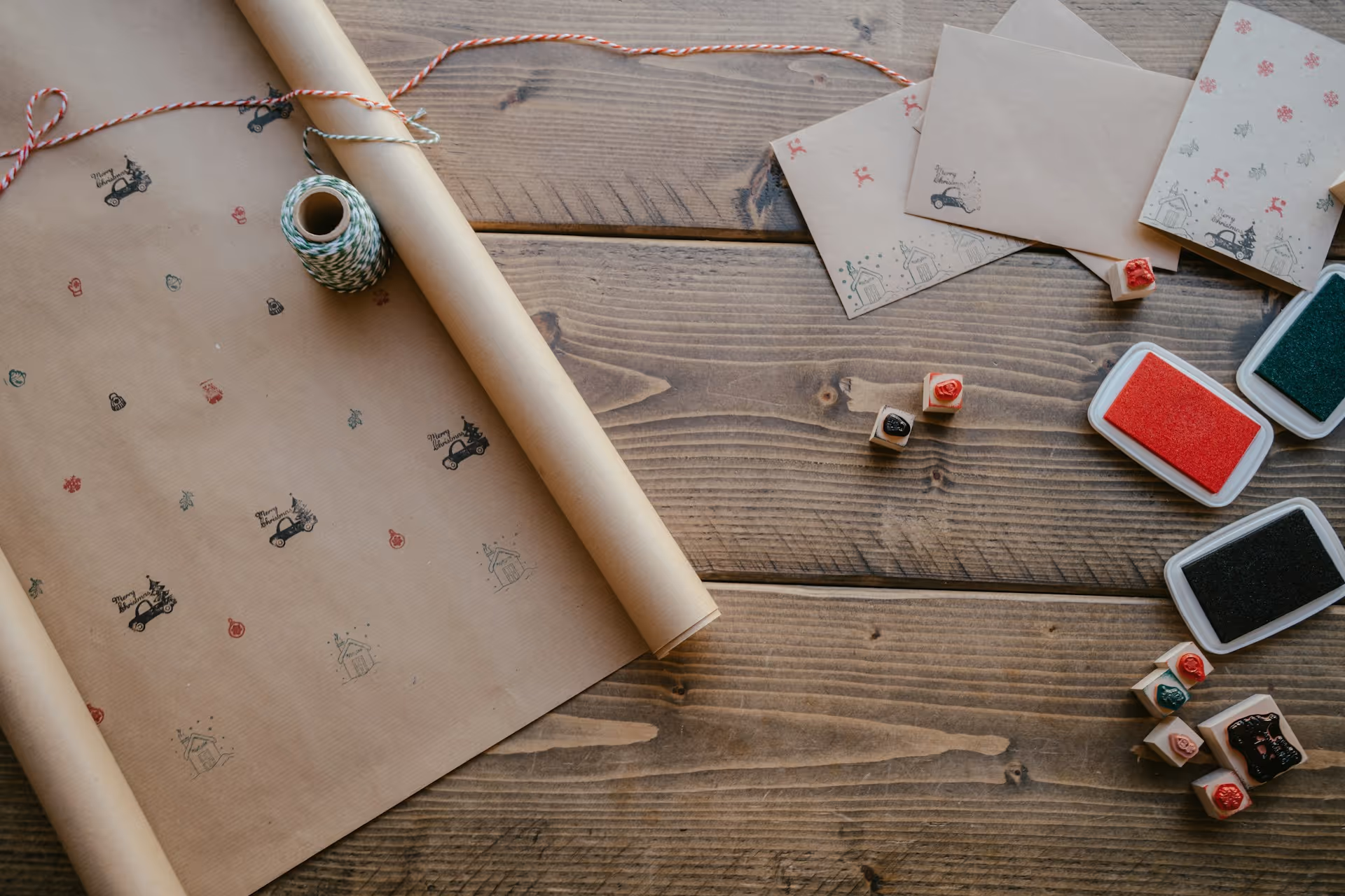 Eco-friendly holiday gift wrapping with recyclable kraft paper, twine, and festive stamps, highlighting sustainable wrapping ideas.