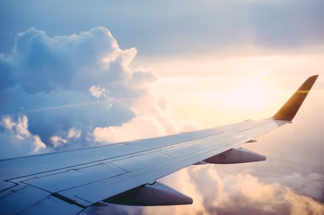 A view of an airplane wing above the clouds.