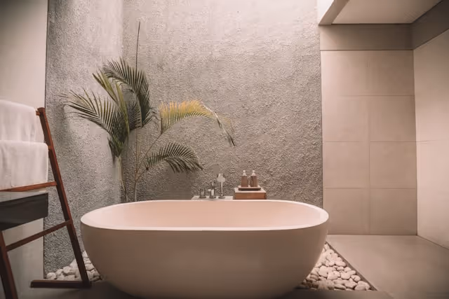 A spa-style bathroom with a bathtub, soft lighting, and natural elements, perfect for relaxation during a babymoon retreat.