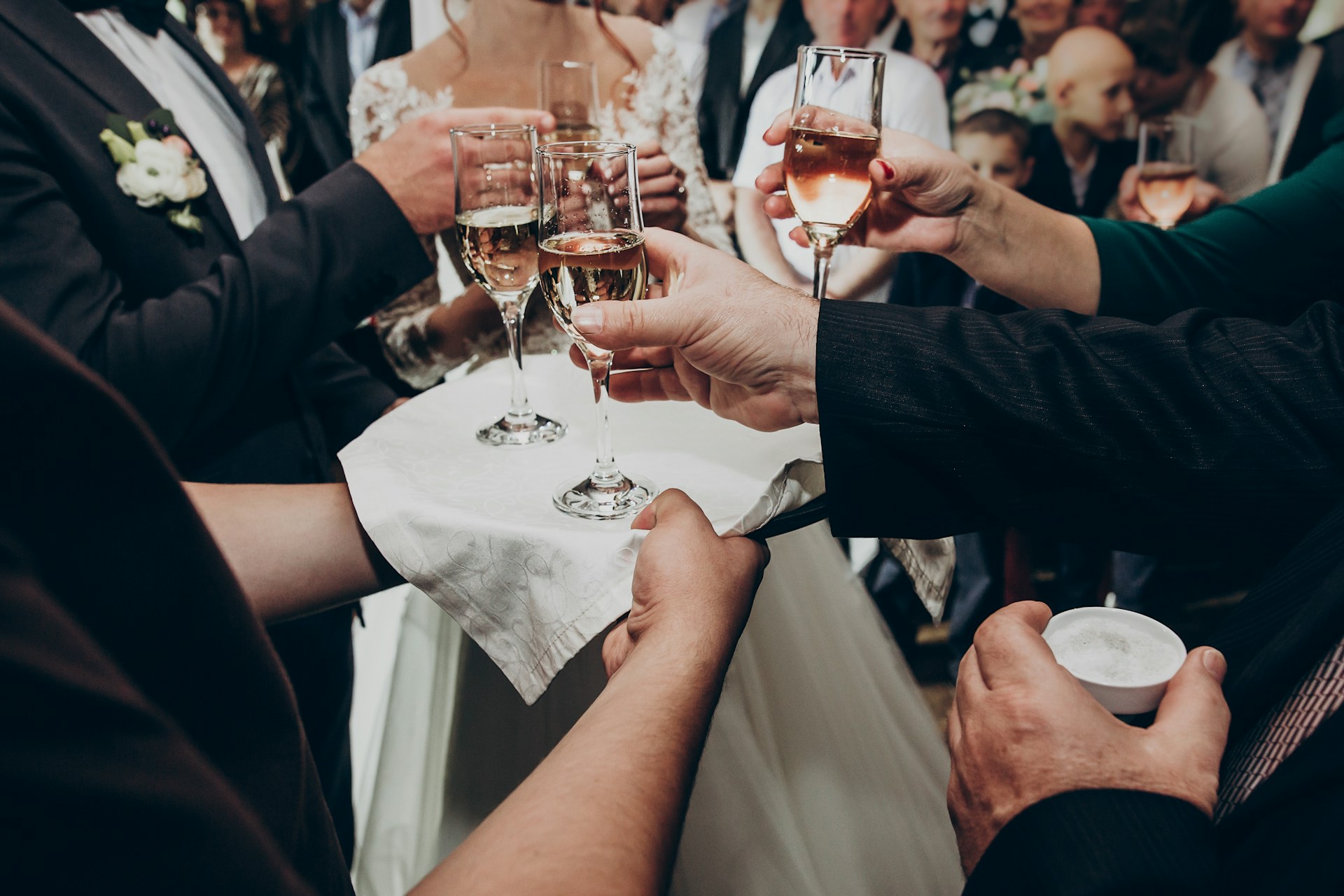 Guests raising glasses of champagne at a formal gala, dressed in evening wear