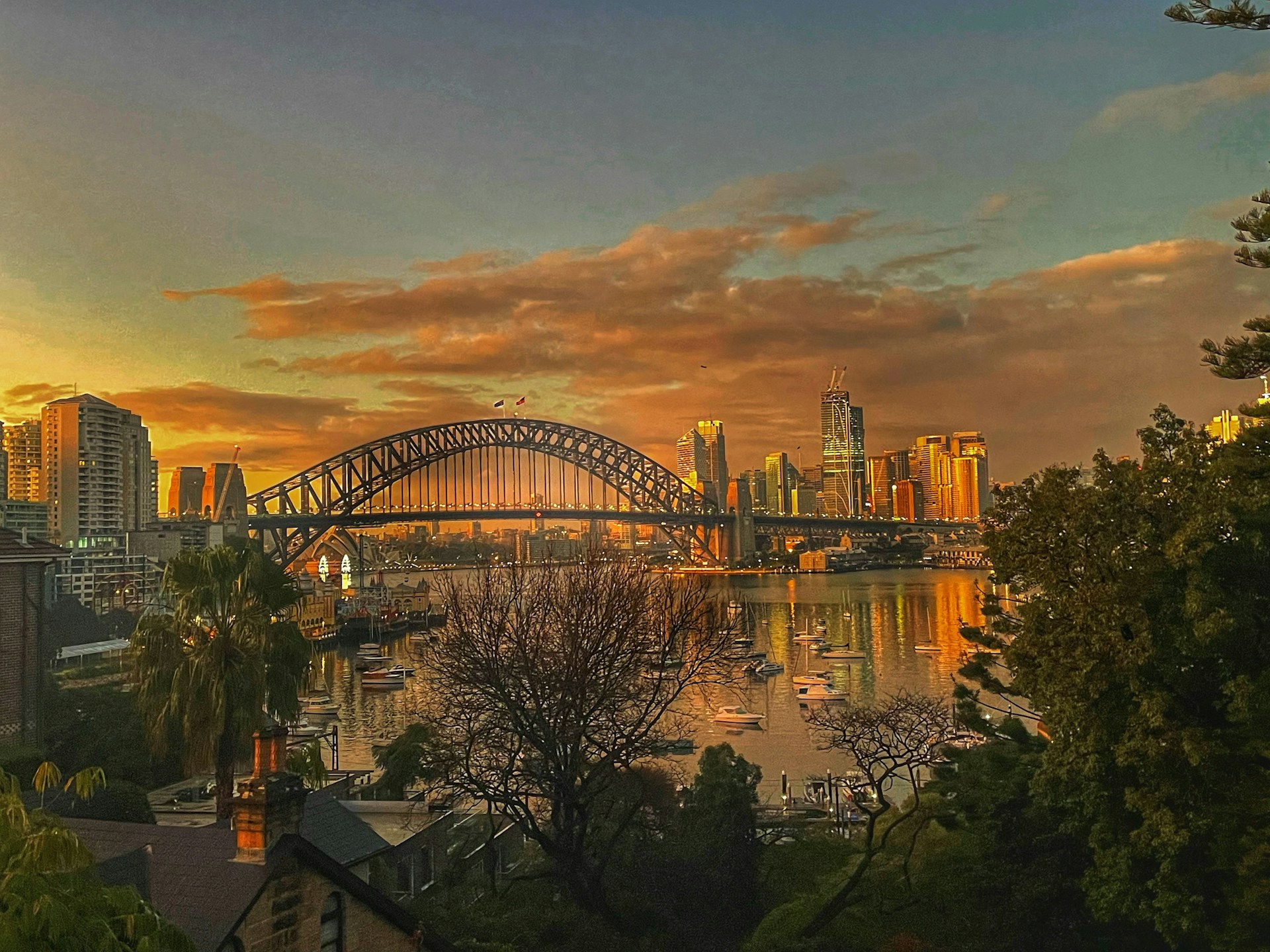 Sunrise over Sydney Harbour Bridge and city skyline, evoking the early morning calm and reliability associated with professional chauffeur airport transfers.