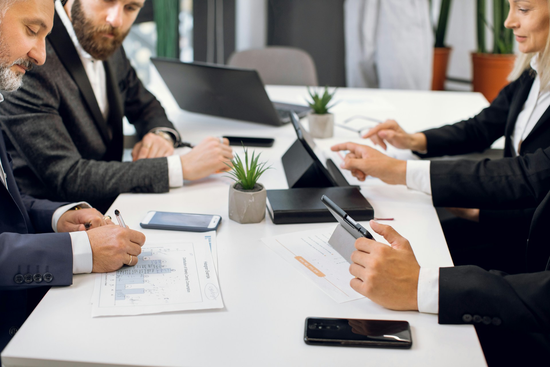 Corporate team meeting around a table with laptops and documents, supporting the theme of professional group planning and business travel logistics in Sydney.
