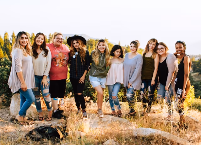 Group of women smiling together outdoors during a girls’ weekend, capturing the fun and connection of a shared getaway.
