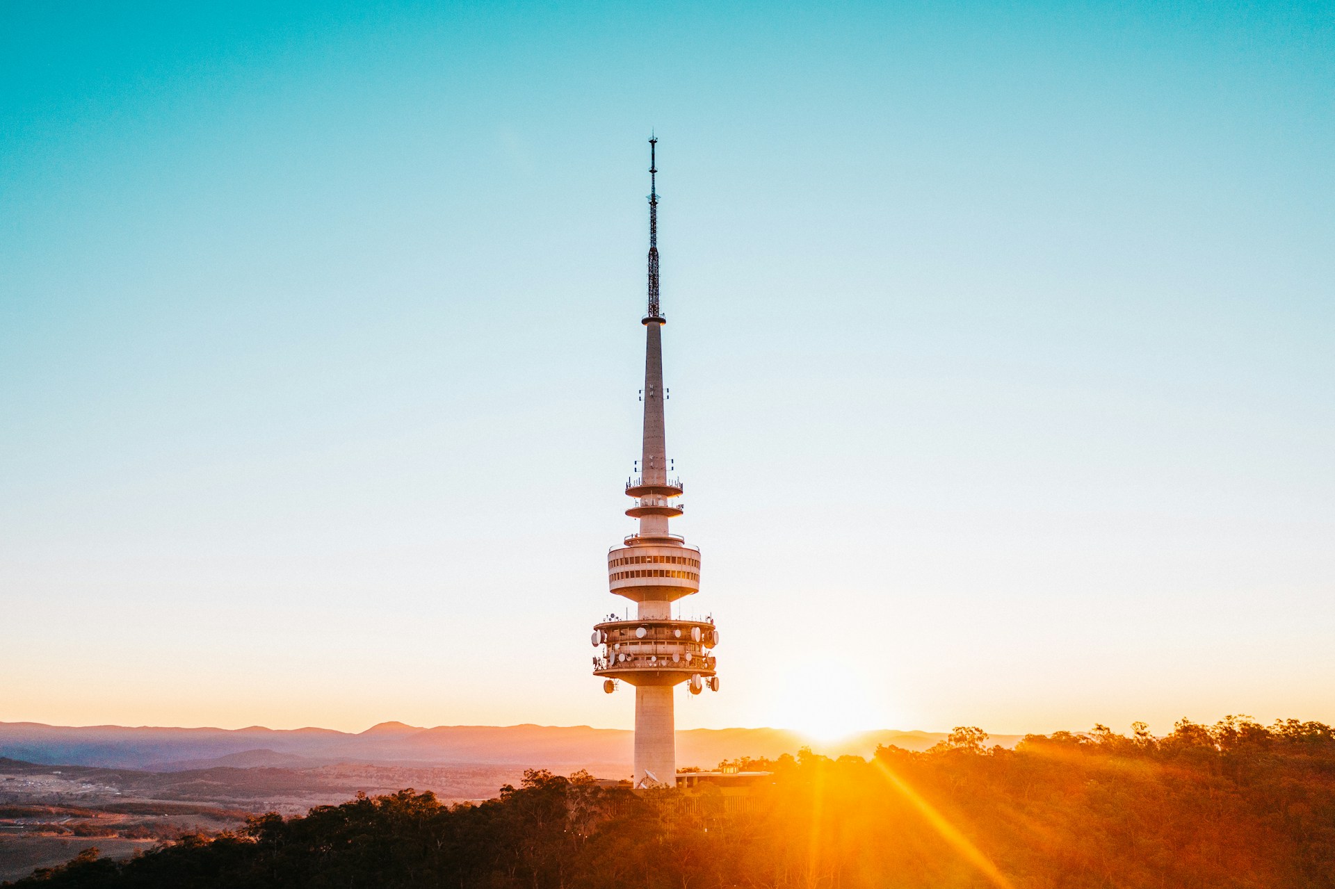 Sunset view of Telstra Tower on Black Mountain overlooking Canberra with warm light and clear sky.