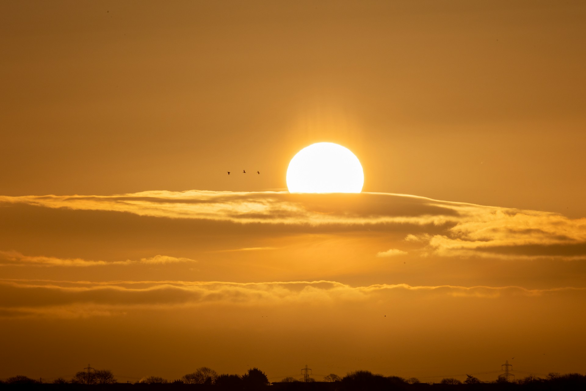 Sunrise above low clouds, representing early morning departures.