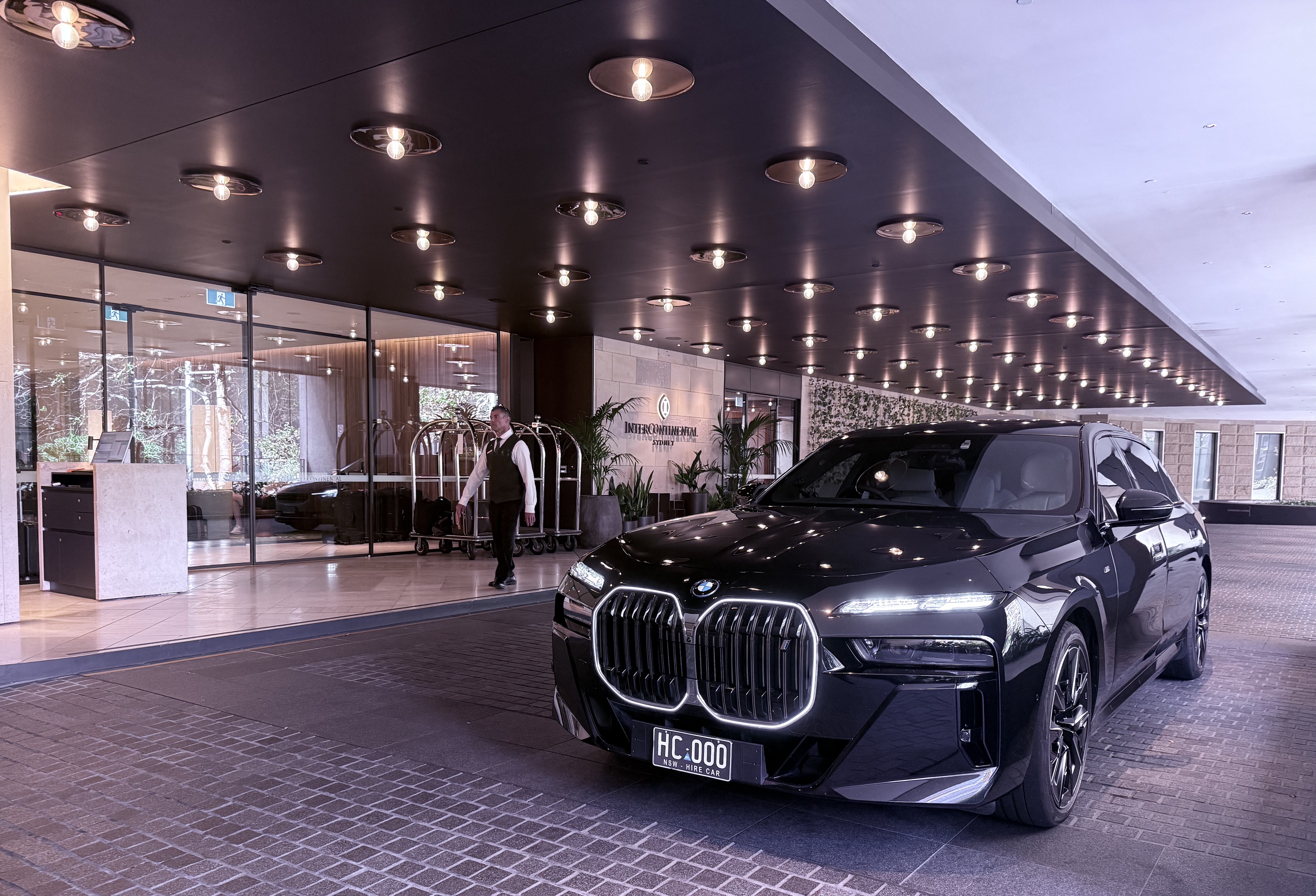 Evoke BMW i7 parked outside the InterContinental Sydney entrance, ready for a premium chauffeur pick-up.