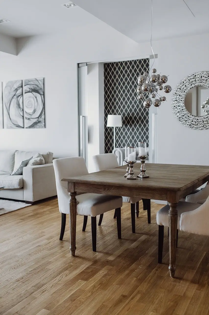 Modern eingerichtetes Wohnzimmer mit Essbereich in einer möblierten Beispiel Monteurwohnung in Wilhelmshaven – stilvolle Unterkunft mit Holzboden, Esstisch und Designleuchte.
