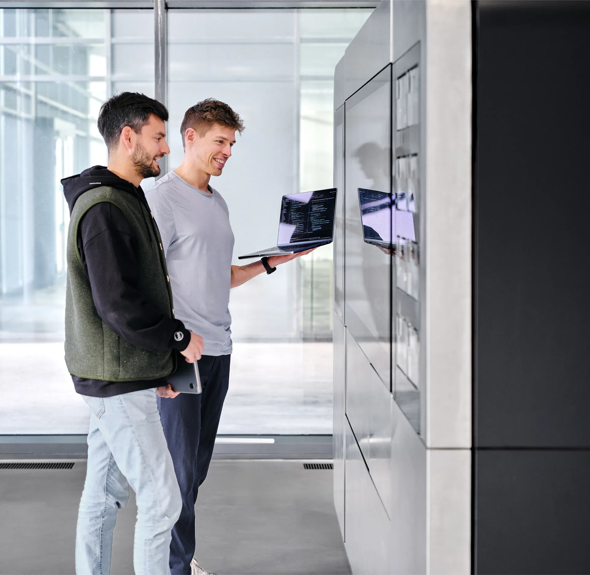 Two engineers standing in front of a CA-1 Series 4 unit, using a laptop with visible code to interface with the machine.