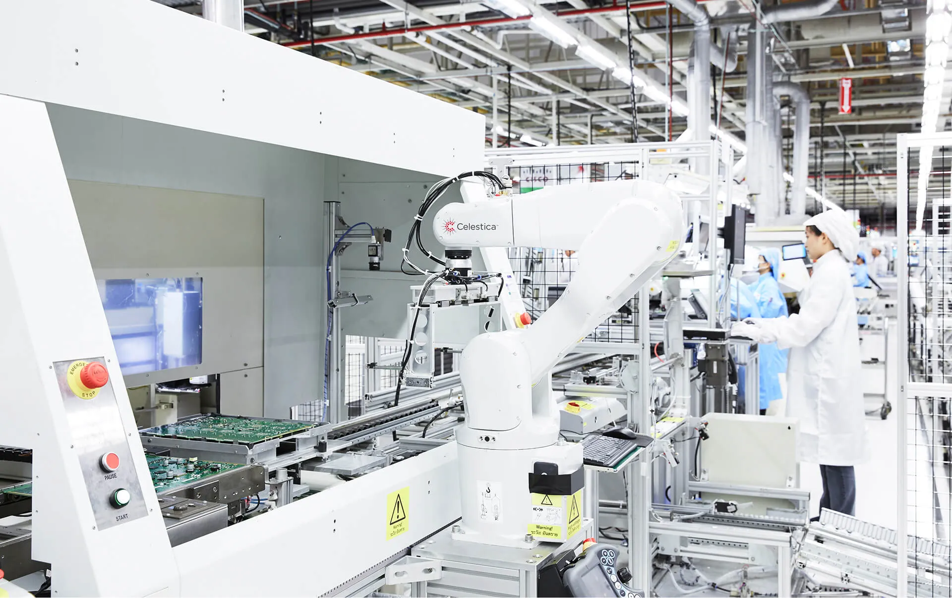 Automated robotic arm labeled Celestica operating on a circuit board assembly line in a clean, high-tech manufacturing facility with technicians in lab coats and protective gear.