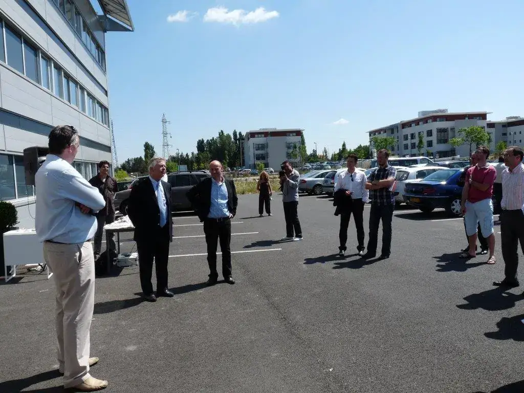 Inauguration de la salle de visioconférence Espace Entreprise Montpellier 2010 : public debout sur le parking ensoleillé pendant les discours
