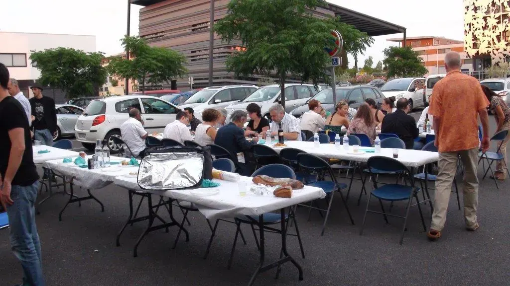Soirée estivale Espace Entreprise juillet 2013 à Montpellier : participants attablés dehors autour de tables blanches sur le parking