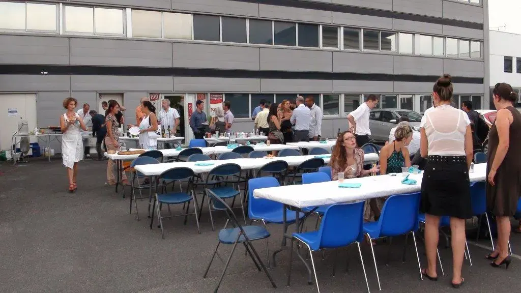 Soirée estivale Espace Entreprise juillet 2013 à Montpellier : tables dressées en extérieur avec convives et chaises bleues