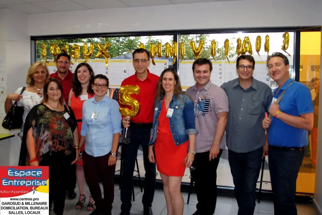 5 ans d'Espace Entreprise Montpellier en 2013 : groupe posant devant la banderole anniversaire dans le hall