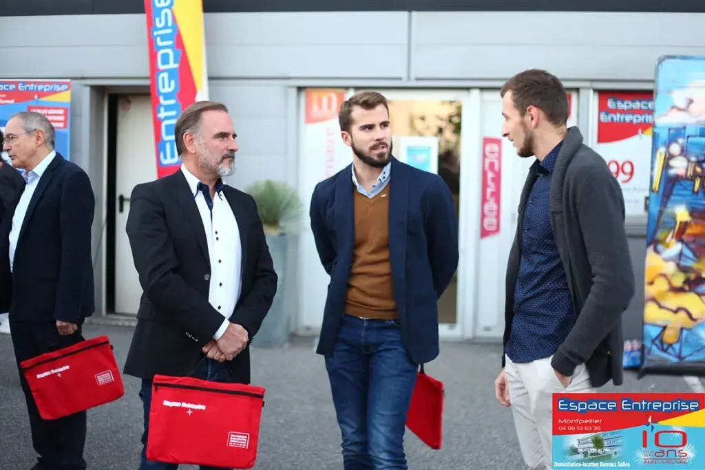 10 ans du centre Espace Entreprise Millénaire à Castelnau-le-Lez en 2018 : invités alignés avec des sacs cadeaux rouges devant le panneau 10 ans