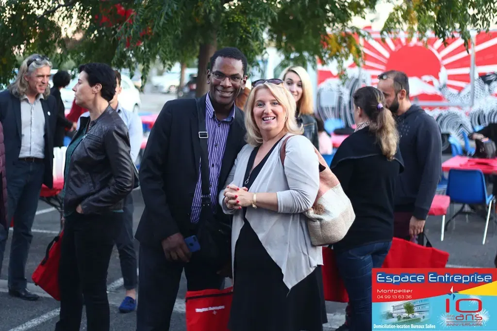 10 ans du centre Espace Entreprise Millénaire à Castelnau-le-Lez en 2018 : participants échangeant en extérieur devant un parasol rouge