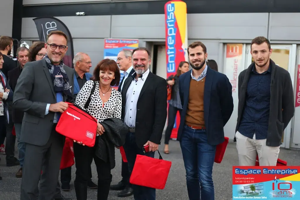 10 ans du centre Espace Entreprise Millénaire à Castelnau-le-Lez en 2018 : groupe de participants posant avec des sacs cadeaux rouges