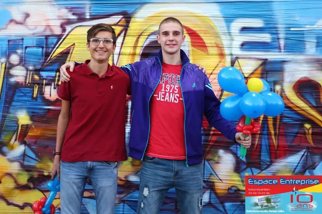 10 ans du centre Espace Entreprise Millénaire à Castelnau-le-Lez en 2018 : deux participants posant devant la fresque graffiti avec ballons