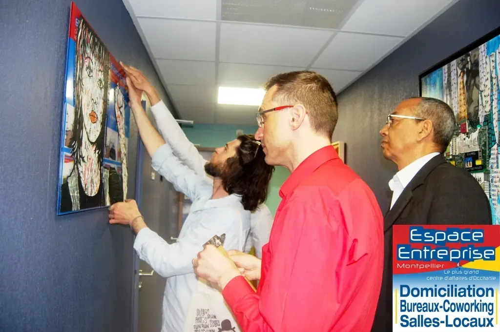 Accrochage de toiles au centre Espace Entreprise Millénaire décembre 2019 : accrochage d'une toile au mur du couloir par plusieurs personnes