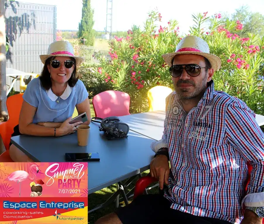 Summer Beach 2021 du Club LR à Montpellier : deux participants attablés posant avec chapeaux de paille