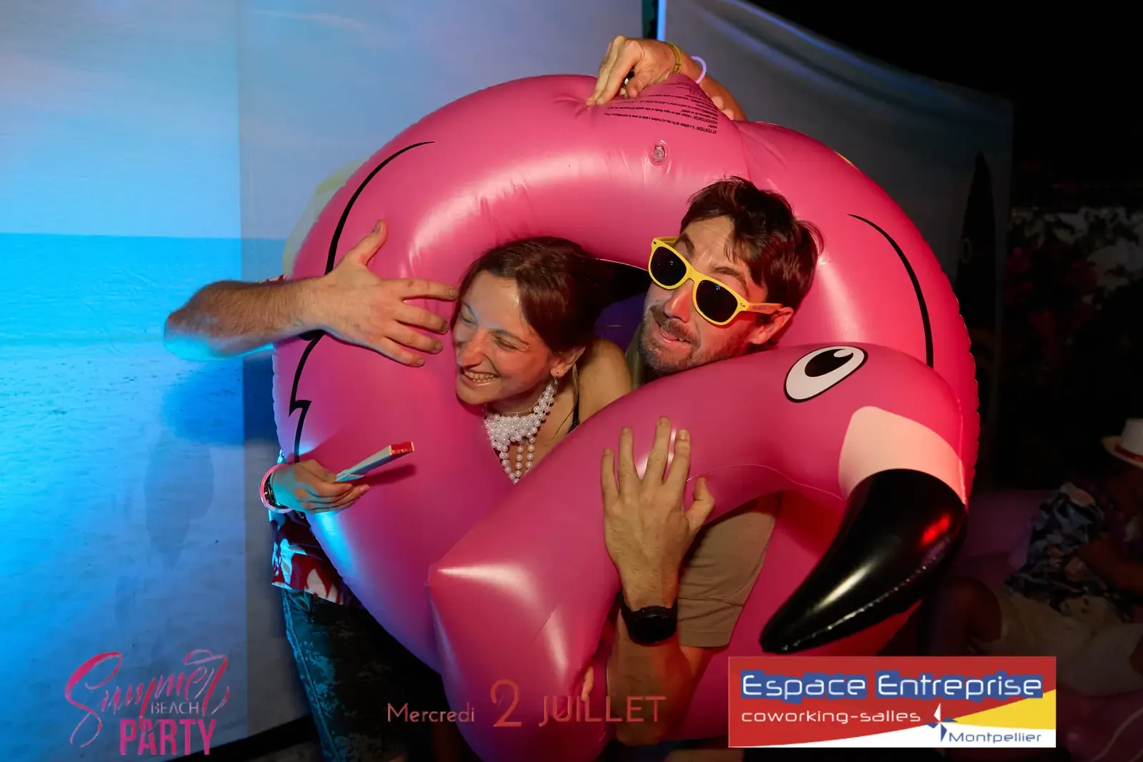 Summer Beach 2025 du Club LR à Montpellier : participants enlacés dans une bouée flamant rose
