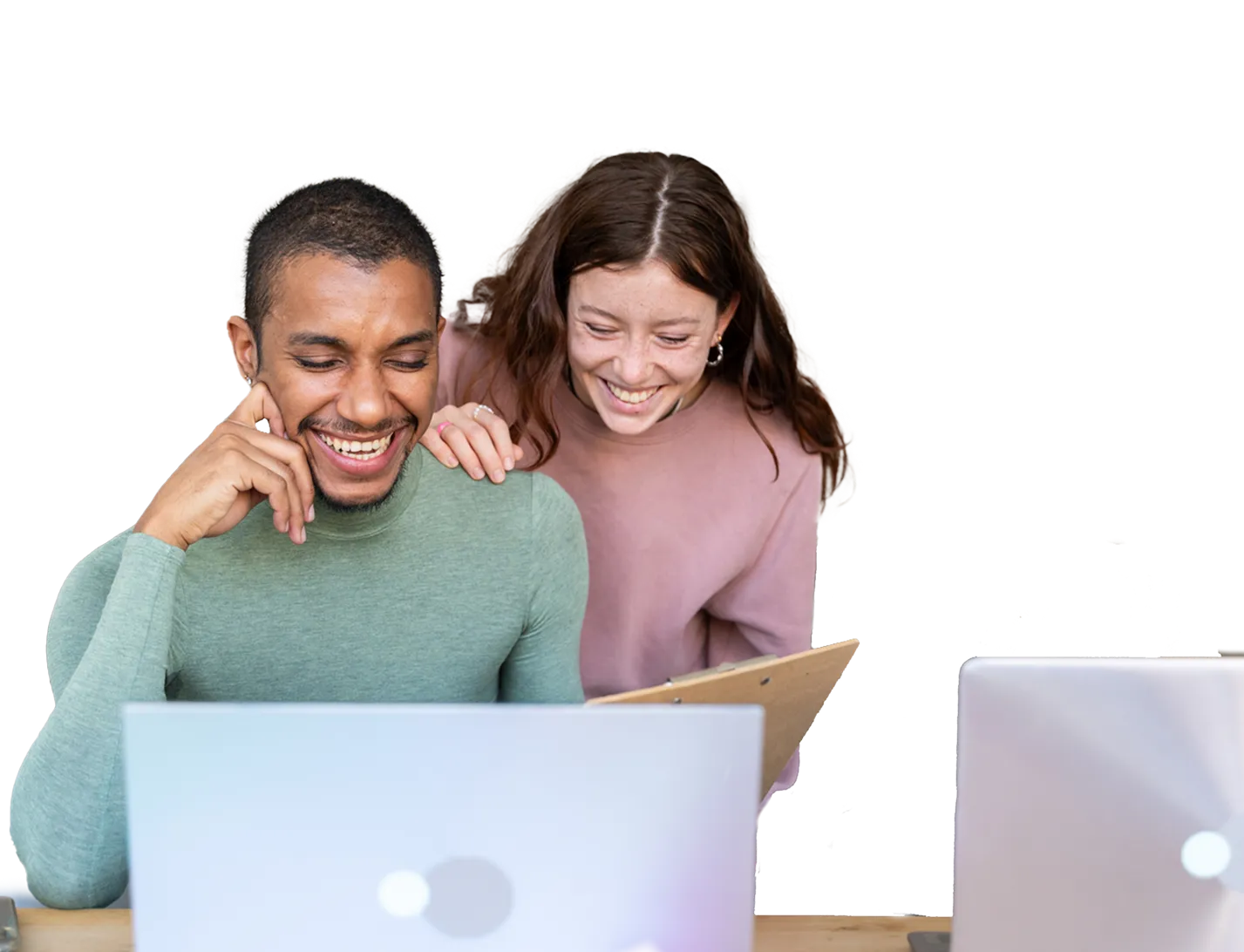 Pareja sonriente ante dos ordenadores portátiles y un cuaderno