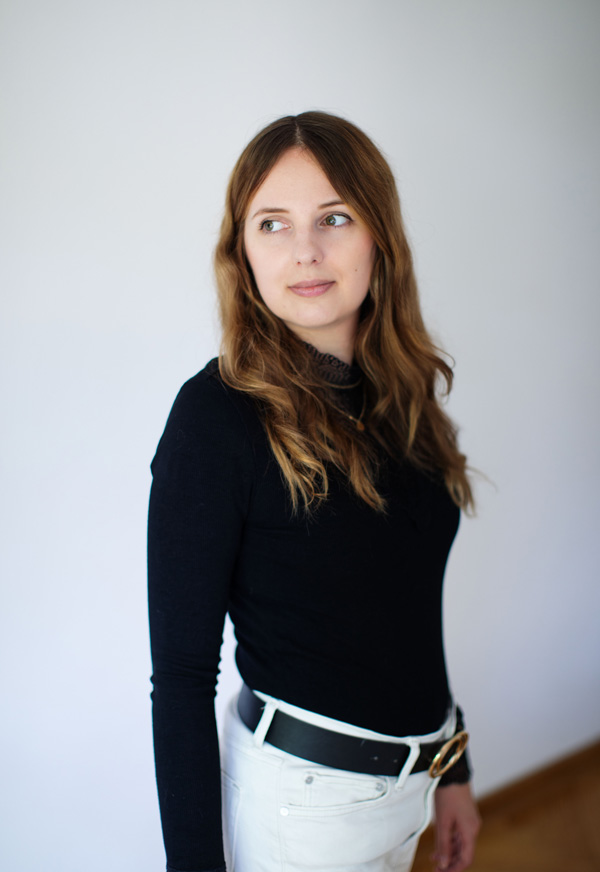 Foto von mir, wie ich vor einer Wand stehe und nicht in die Kamera schaue