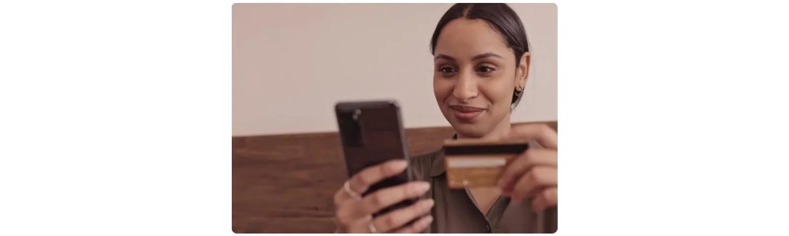 Cliente réglant un achat sur son smartphone avec sa carte bancaire