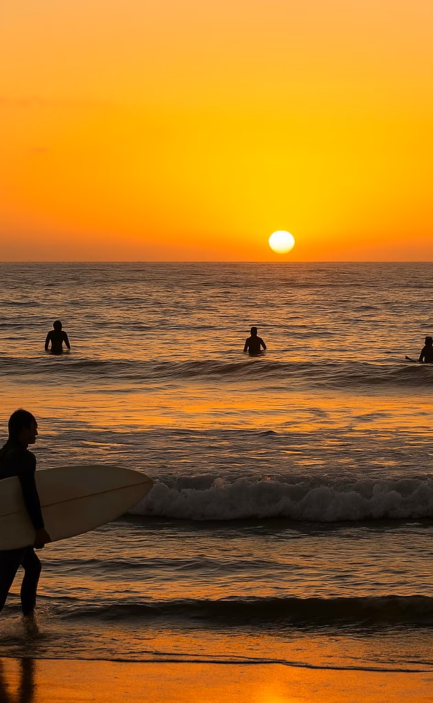 サンディエゴの夕暮れ時、海で波乗りを楽しむサーファーたち