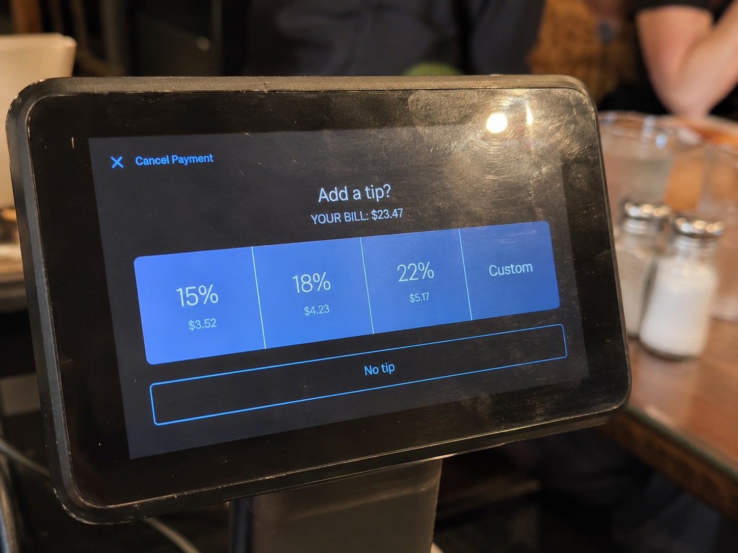 Card reader showing typical tip options in a California restaurant, illustrating tipping culture for international students.
