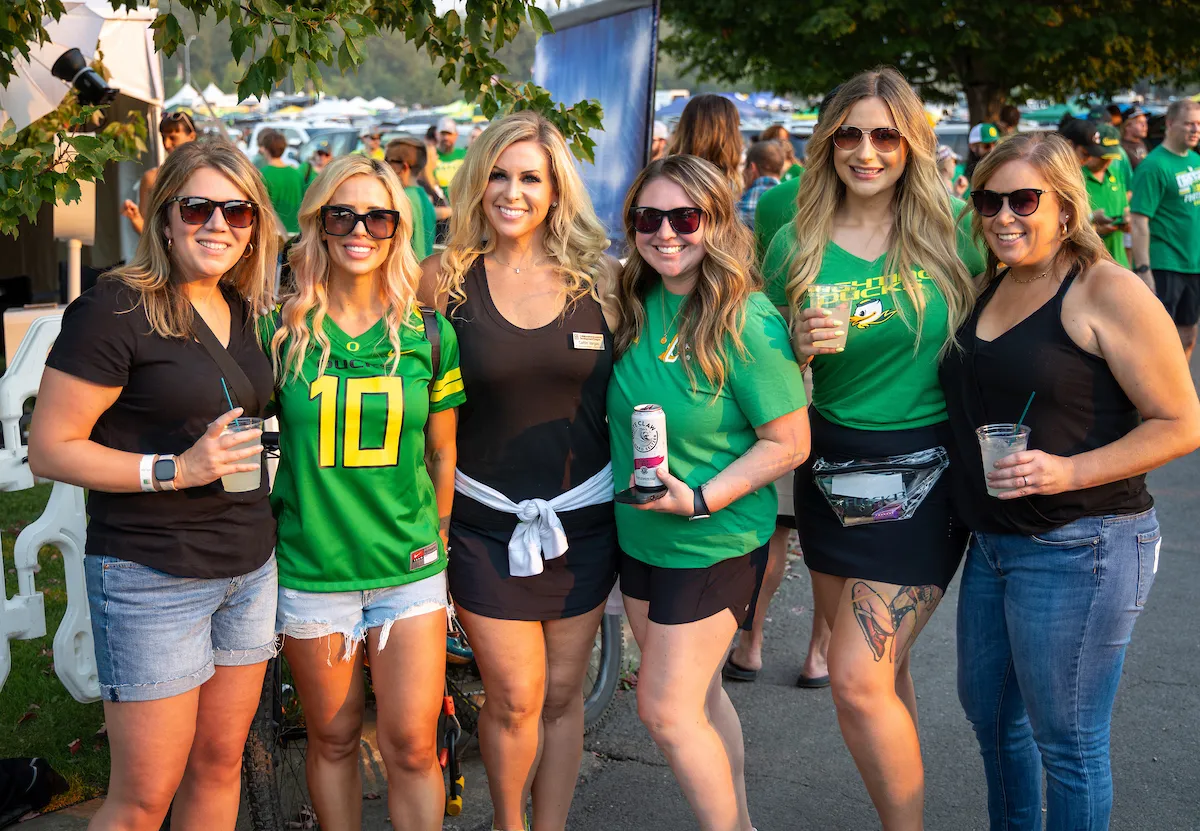 A group of women in Oregon Ducks gear pose for a photo.