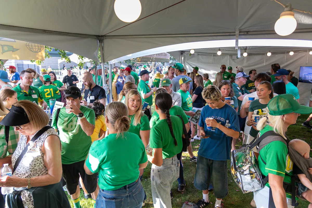 A diverse group of people gathered under tents, engaged in conversation and sharing ideas.