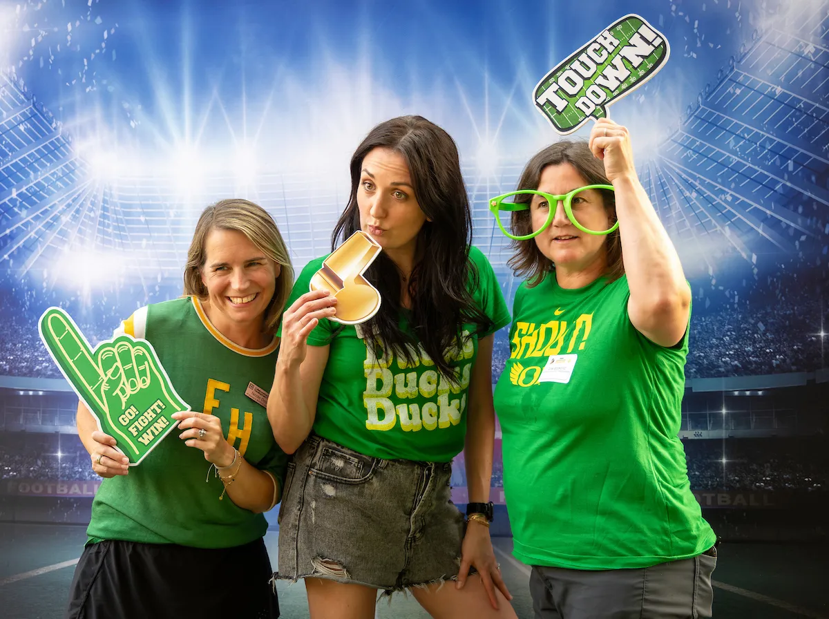 Three women pose at the photo-op background for a fun picture.