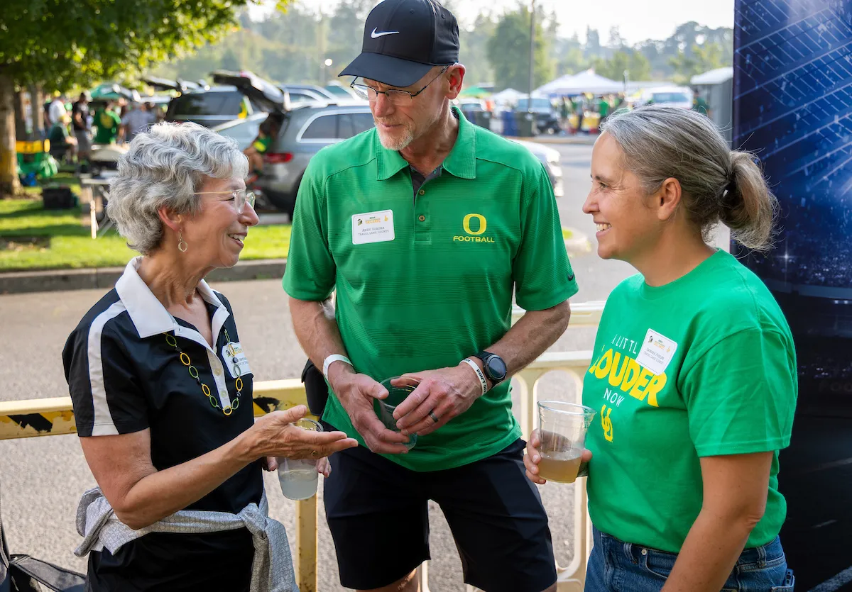 Three people having a thoughtful discussion at the Word Class Industries Tailgate event.