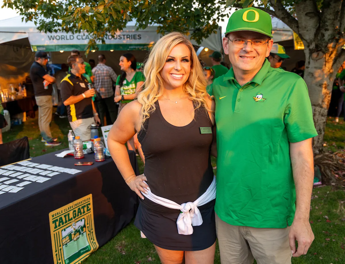 Two people pose for a photo at the Tailgate event.