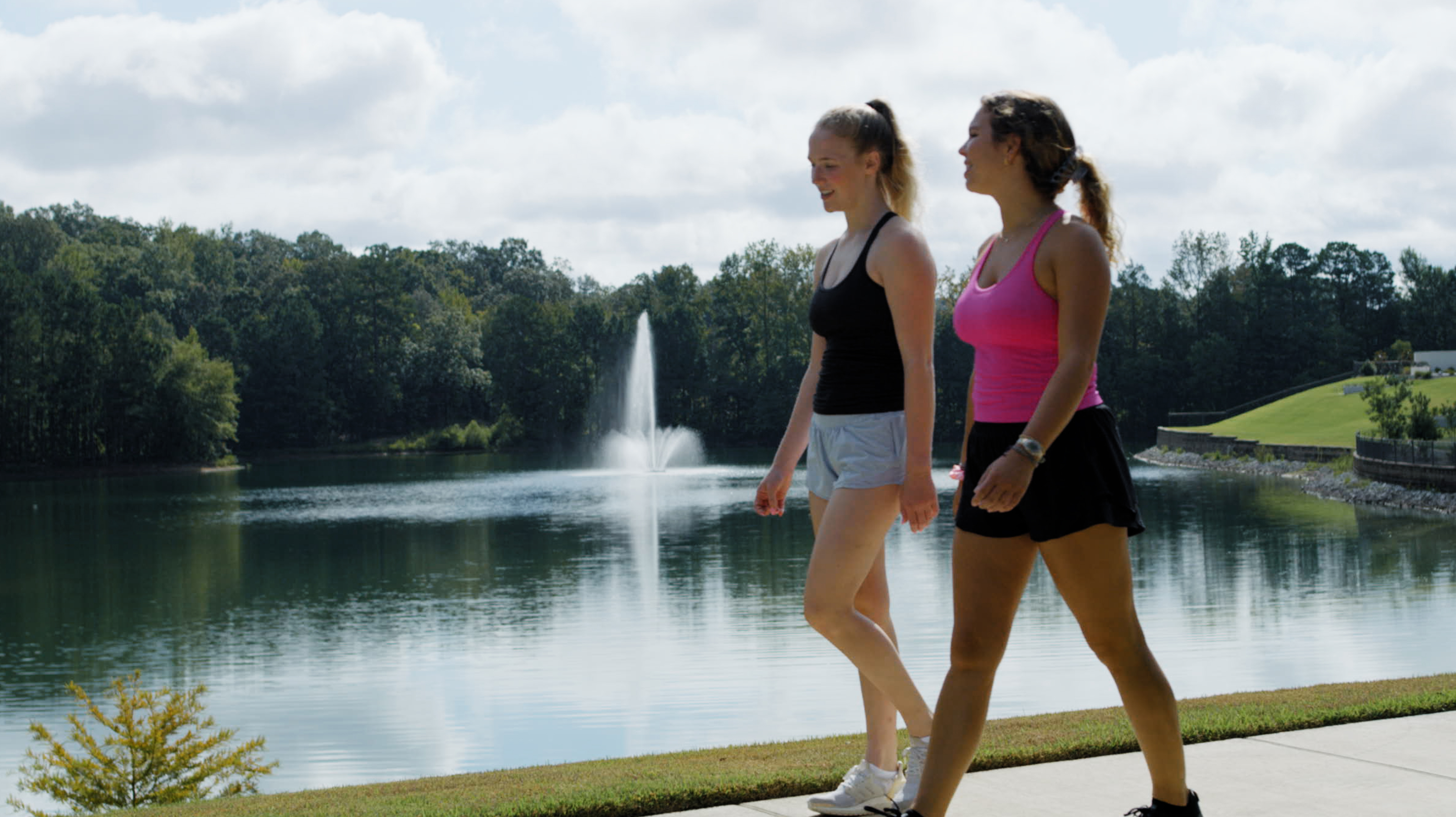 girls walking trail by pond