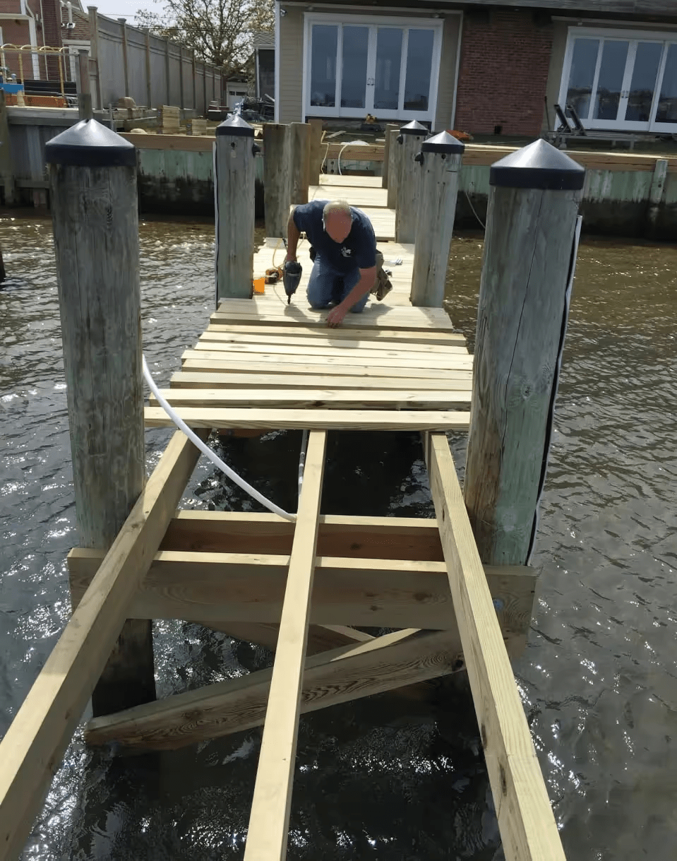 professional marine deck builder reviewing plans with a waterfront property owner - deck builders Massapequa