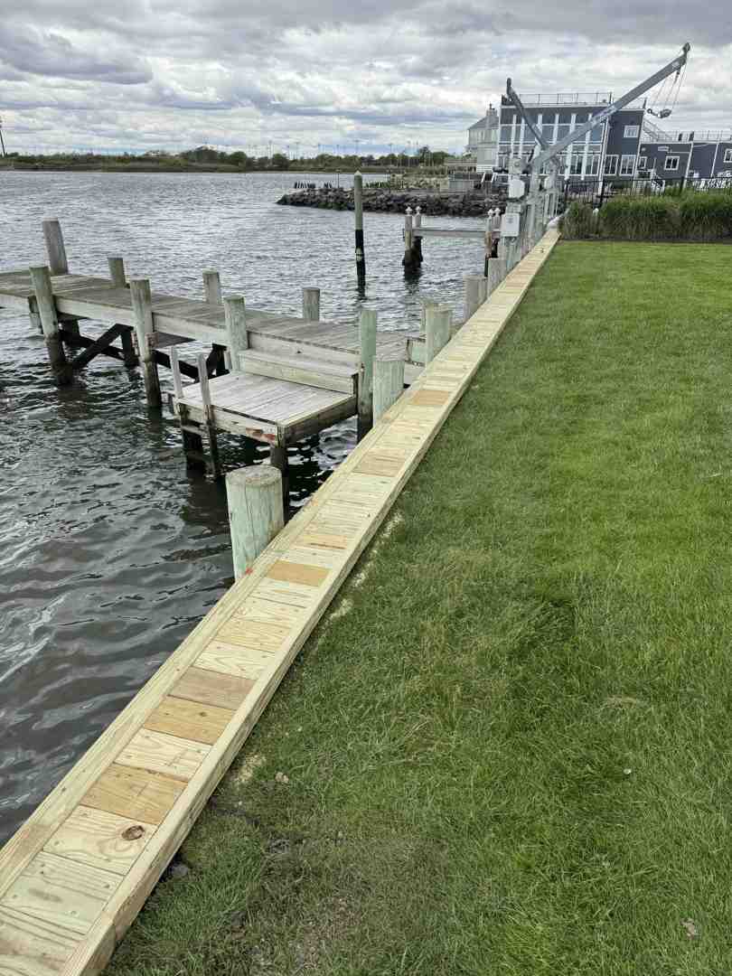Finished multi-level composite deck with integrated lighting and glass railings overlooking a Long Island bay
