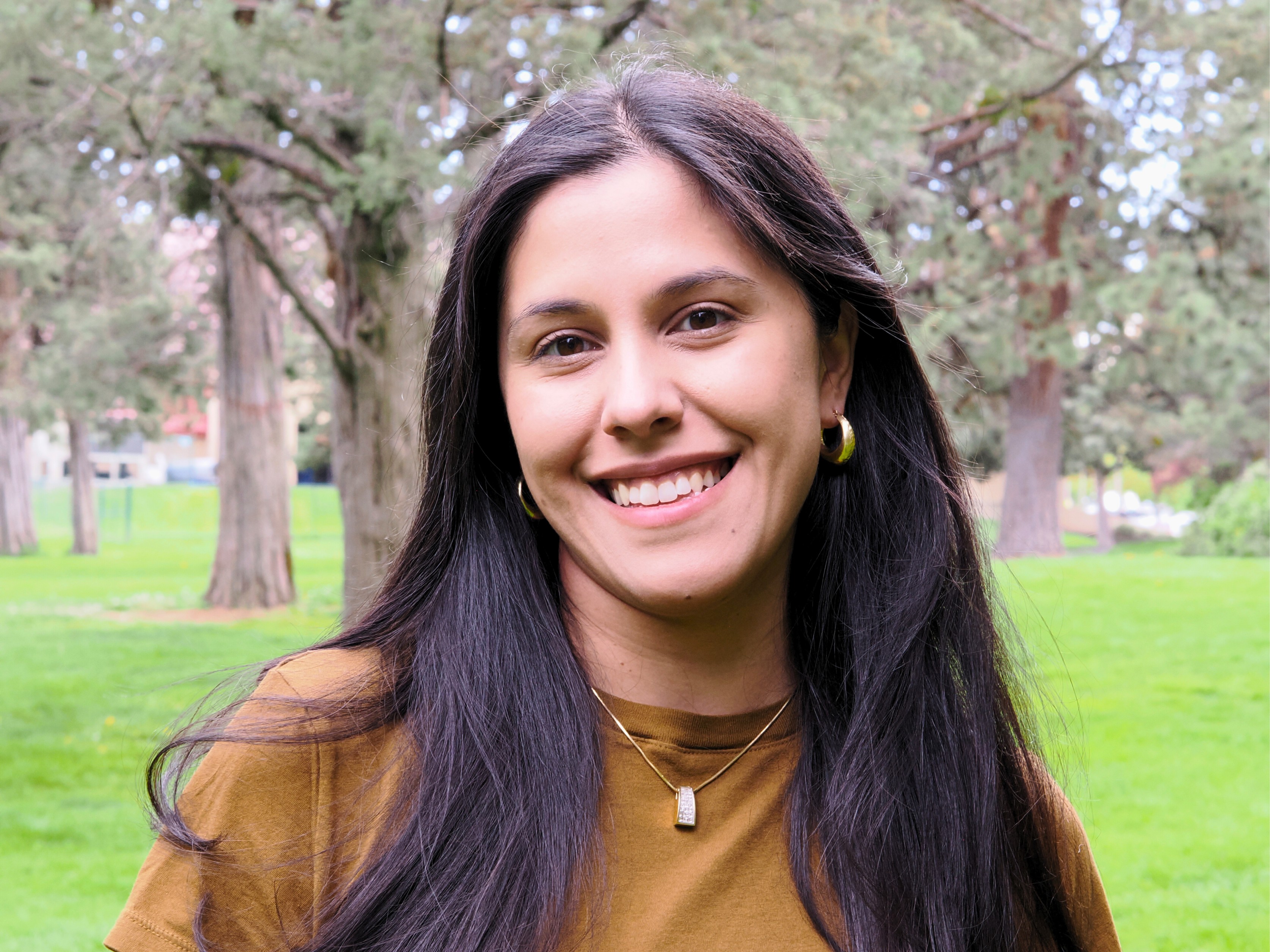 Mariam Hameed, FNP-C. Smiling Profile in front of green trees